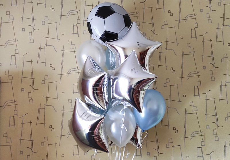 Подарочный букет из шаров с гелием на футбольную тему для мальчика на день рождения с фольгированным шаром в виде футбольного мяча, пятью серебряными звездами из фольги и гелиевыми шарами голубого и белого цвета.